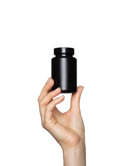 A young woman's hand holds a black plastic bottle isolated on a white background. Mockup for...