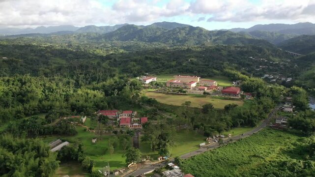 Drone view of UPR - University of Puerto Rico in Utuado surrounded by green spaces and lush hills