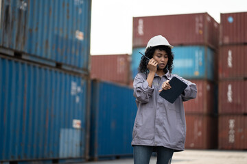 Fototapeta premium Asia worker woman use walkie talkie working with checking container at container site 