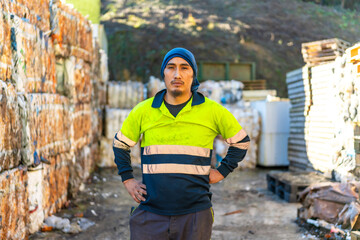 Portrait of a manual worker among recycled plastic bales