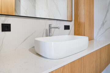 Modern bathroom design featuring a stylish sink with wooden accents