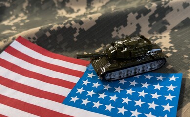 War, military threat, military power concept. USA. Tanks toy near american flag on grey background 