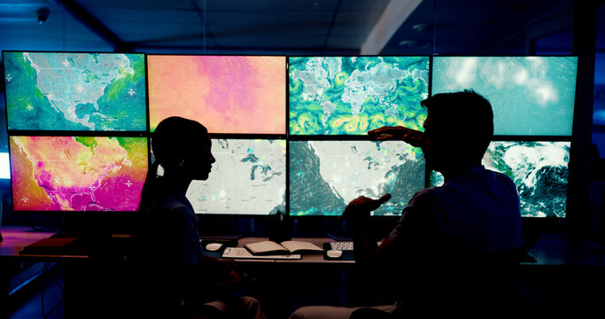 Computer, screen and maps with people in control room for storm tracking, satellite forecast or planning weather pattern. Back, meteorology team or radar data for climate monitor, silhouette or night