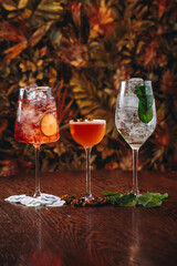 beautiful cocktails in warm colors on a flower background. cocktail or bar menu concept.