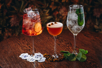 beautiful cocktails in warm colors on a flower background. cocktail or bar menu concept.