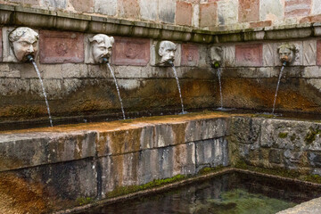 Closeup of the square of the fountain of the 99 spouts (In Italian: Fontana delle 99 cannelle) located in the historic center of L'Aquila, in Abruzzo, Italy. It's a monumental fountain.