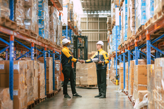 Warehouse workers join team together deal shaking hand in warehouse building in logistic industry