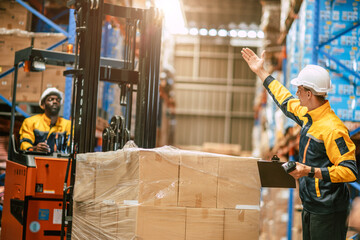 Warehouse worker in duty stock control by forklift truck moving products cargo inventory management