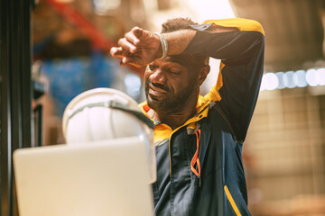 African black male worker tired stressed sweat from hot weather in summer working indoor warehouse