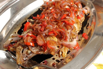 Deep fried crispy whole fish with onion chilli sauce topping garnish