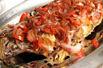 Deep fried crispy whole fish with onion chilli sauce topping garnish