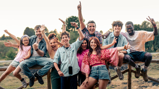 Happy multigenerational friends celebrating together outdoor at sunset - Powered by Adobe