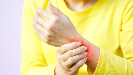 Fototapeta premium Wrist pain chronic therapy concept. A person holding their wrist, showing signs of discomfort or pain.