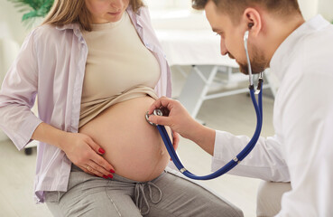 Young pregnant woman checkups visiting doctor in clinic, medical gynecologist examines fetal heartbeat, rate with stethoscope, expectant mother and prenatal health care, healthy pregnancy, testing