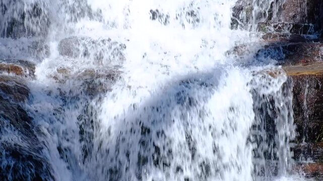 Closeup of Nanu Oya Falls waterfall with fast flowing water cascading rocks in Nuwara Eliya district highlands of Sri Lanka