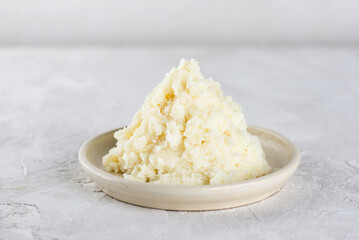 Edible unrefined shea butter in a plate on light table.