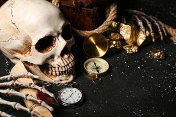 Travel equipment with golden nuggets, human skull and net on black background
