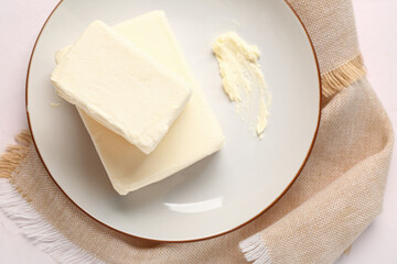 Plate with fresh butter on white background