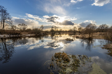 A calm lake with a cloudy sky in the background