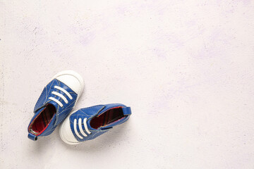Naklejka premium Stylish baby shoes on grunge white background