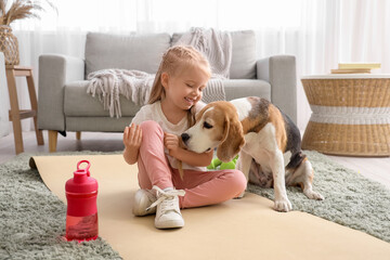 Sporty little girl with Beagle dog at home