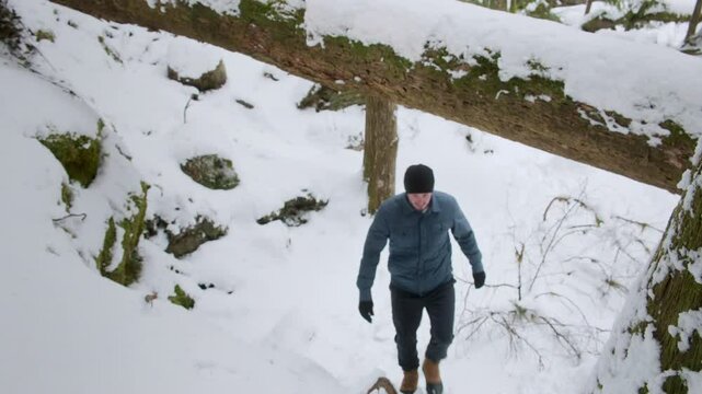 Outdoorsman Hiking in Snow Covered Forest