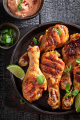 Hot grilled chicken leg with mustard sauce and lime.