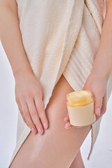 A woman applying cream, body oil – Regular skin care, soft and smooth skin