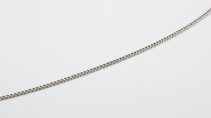 Close up of silver chain jewelry on neutral background highlighting texture, elegance, minimalism, and fashion