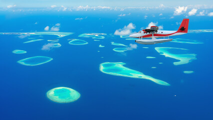 Seaplane above a aerial view of beautiful tropical island among blue sea water at Maldives paradise with boat on background