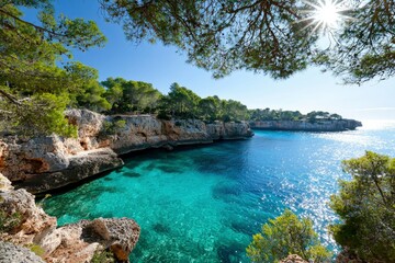 Obraz premium Coastal view in Mallorca, Spain, framed by trees, capturing a peaceful scene