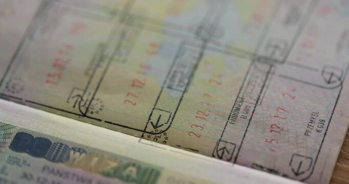 Close up part of foreign passport with foreign visas border stamps permits to enter countries concept of traveling around the world.
