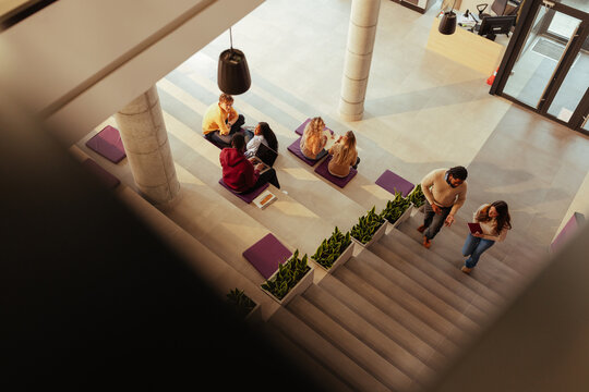 University students collaborating and walking in modern hallway