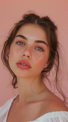 Obraz premium A soft and elegant close-up portrait of a young woman with glowing skin, freckles, and minimal makeup, exuding natural beauty and charm. 