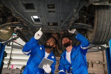 Team Auto mechanic are checking and repair maintenance auto engine is problems at car repair shop.