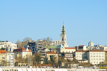 Fototapeta premium Cityscape from Belgrade with one of the most recognizable symbols of the capital of Serbia - the bell tower of the Orthodox Cathedral of St. Archangel Michael. Old buildings and modern architecture.