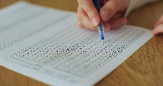 School or university woman students hands taking exams, writing examination room with holding pencil on optical form answers paper sheet.