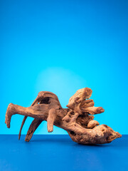 A detailed close-up of natural wooden driftwood, crafted for enhancing aquariums or terrariums, set against a vibrant purple background.