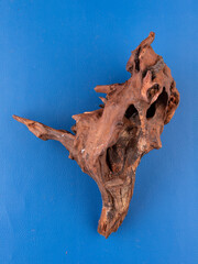 A detailed close-up of unique natural driftwood, expertly crafted to elevate the decor of aquariums or terrariums, set against a bold purple background.