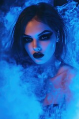 Female with dark makeup in ethereal light, emitting blue smoke