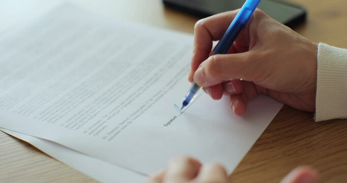 Close up unrecognizable woman filling a residential lease agreement, lease contract. Signing contract of purchase, sale or rental of your home.