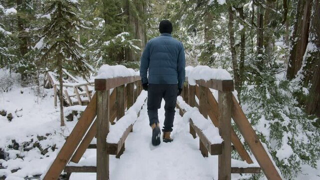 Snowy Winter Hike Background with Man Crossing Wood Footbridge
