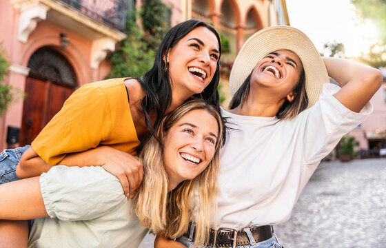 Fototapeta Three diverse young women having fun together on city street - Beautiful girls laughing outdoors