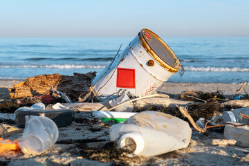 Garbage pollution from discarded plastic waste, chemical barrels ocean trash in summer. Discarded trash is a threat to marine biodiversity, raising awareness of ocean cleanup efforts responsibility. 