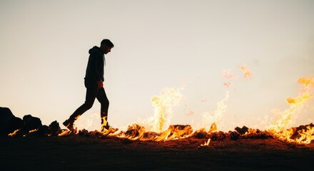 Fototapeta premium Person walking amidst flames, concept of resilience and challenge
