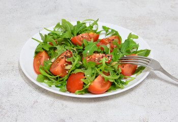 Fresh and healthy salad with tomatoes and arugula and flex seeds