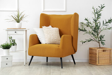 Stylish interior of living room with brown armchair, coffee table and houseplant