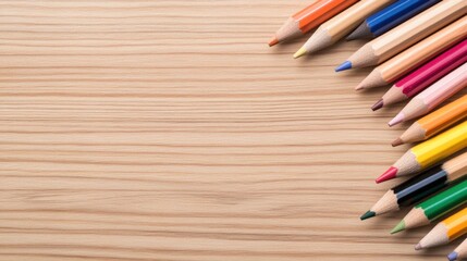 Colorful Wooden Colored Pencils Arranged on Light Wood Surface with Space for Text or Design Elements
