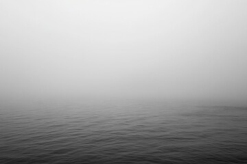 Fototapeta premium A body of water with a foggy sky in the background. simple, elegant gradient background in gray tones, providing an empty space for creative design use.