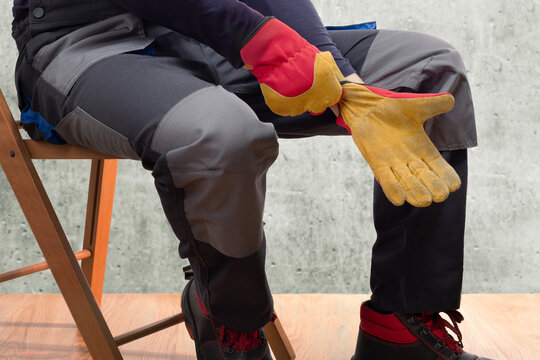 Construction worker putting on protective gloves.